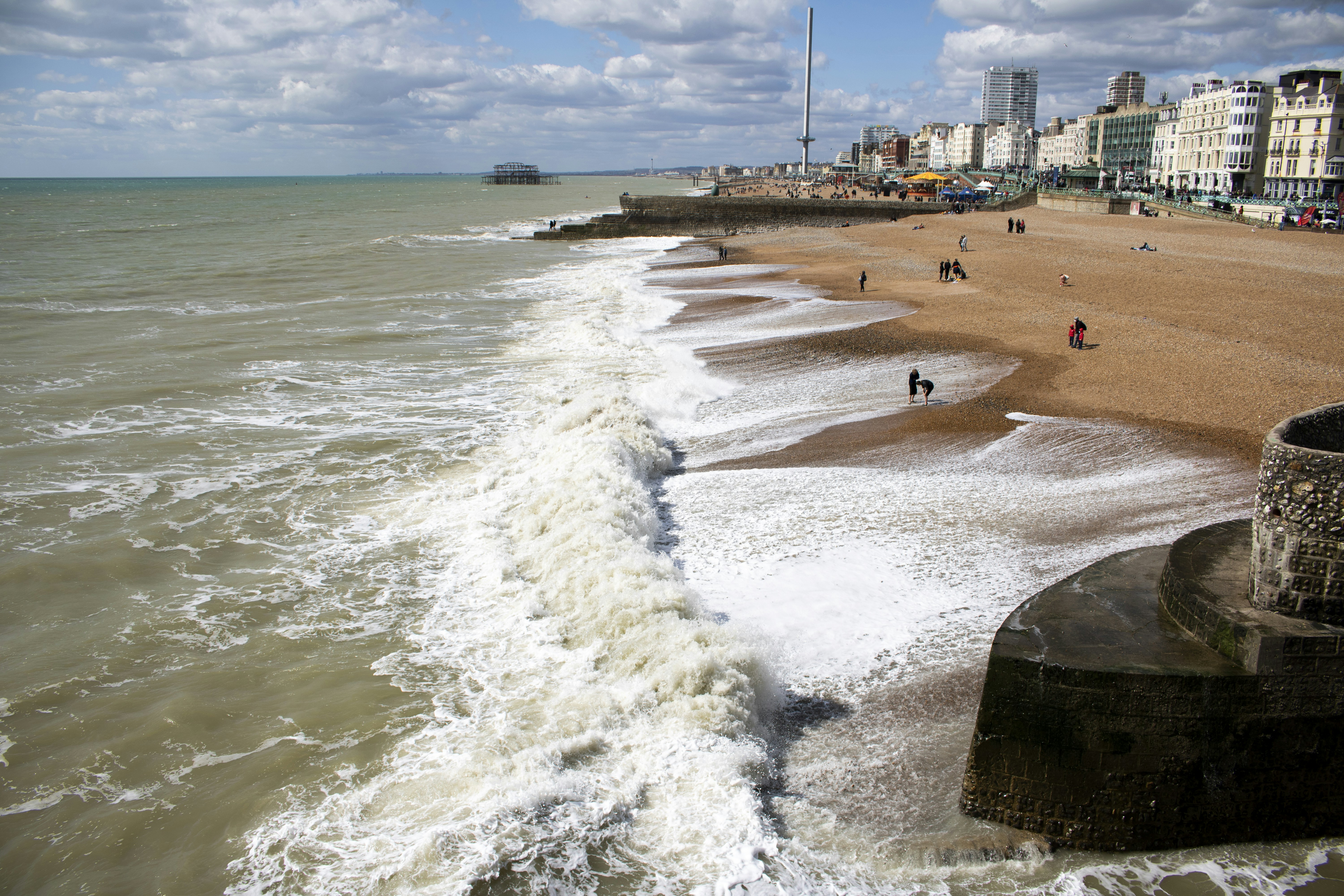a view of a beach with people walking on it