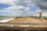 Seaside resort with beachfront properties and tourists relaxing by the water.