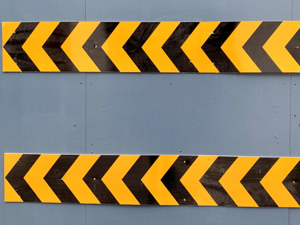 a couple of yellow and black arrows on a wall
