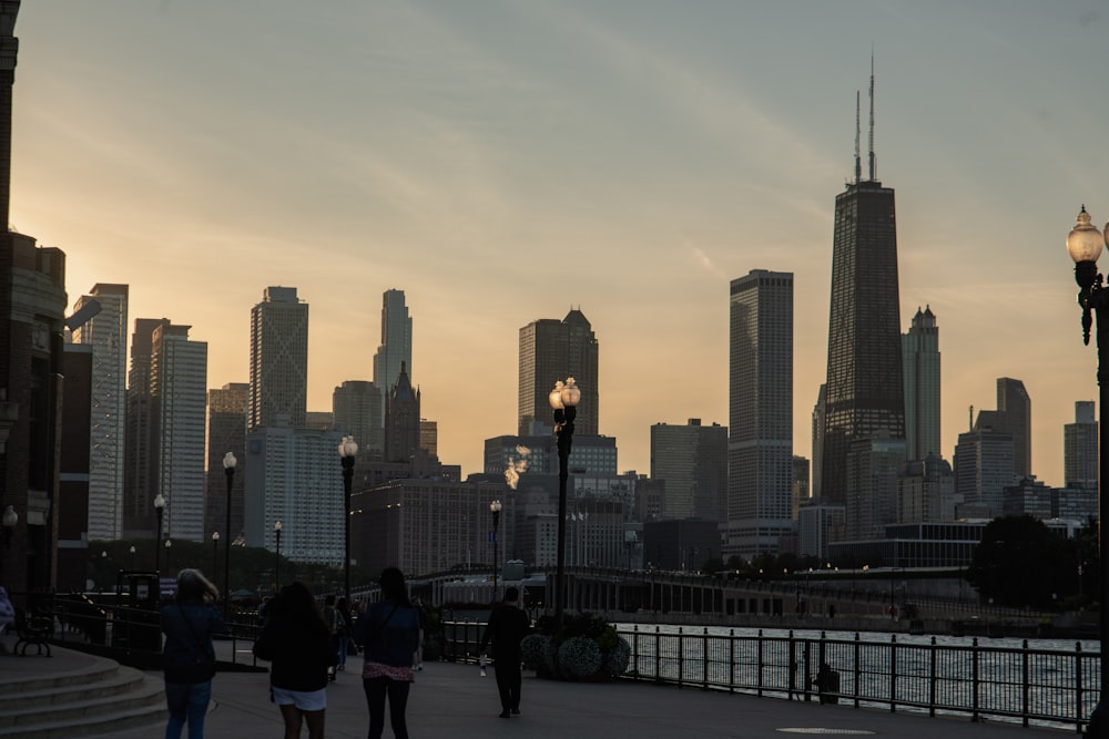 a group of people walking across a bridge next to tall buildings