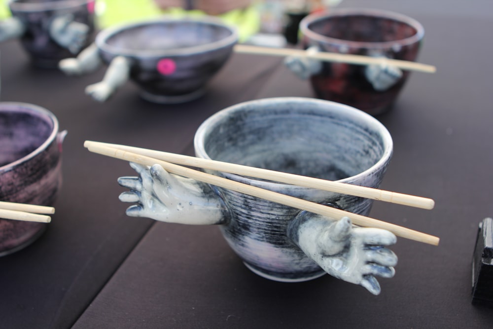 a close up of a bowl with chopsticks in it