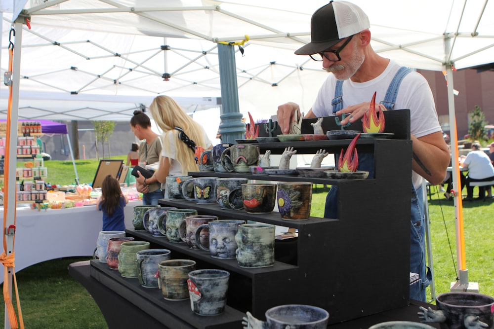 a man standing in front of a display of vases