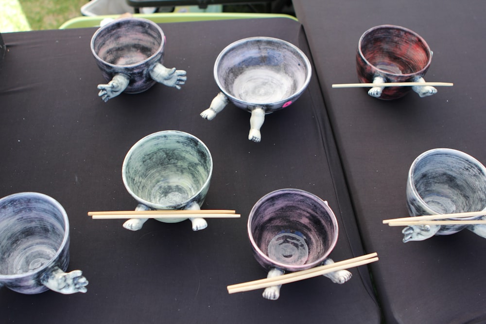 a table topped with bowls and chopsticks on top of a table