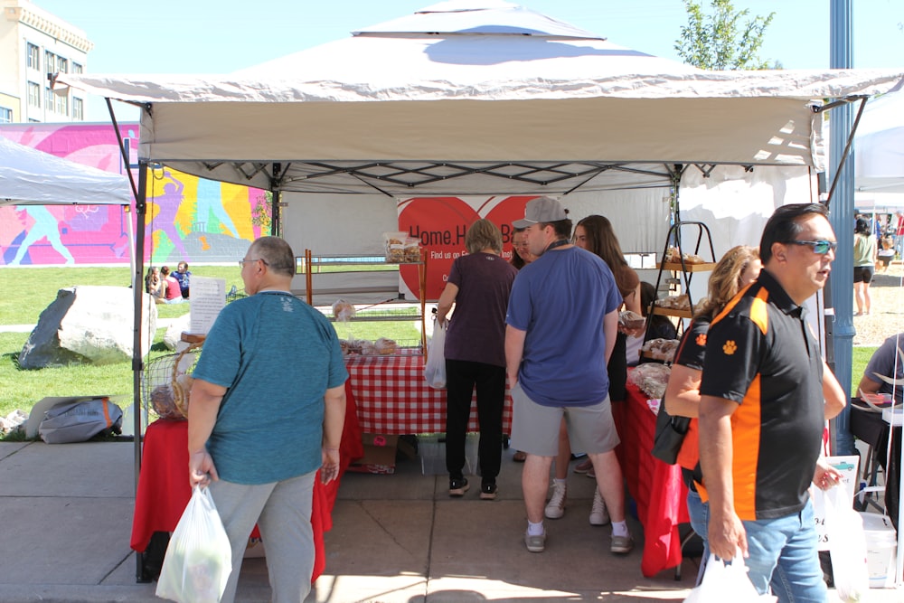 a group of people standing under a tent