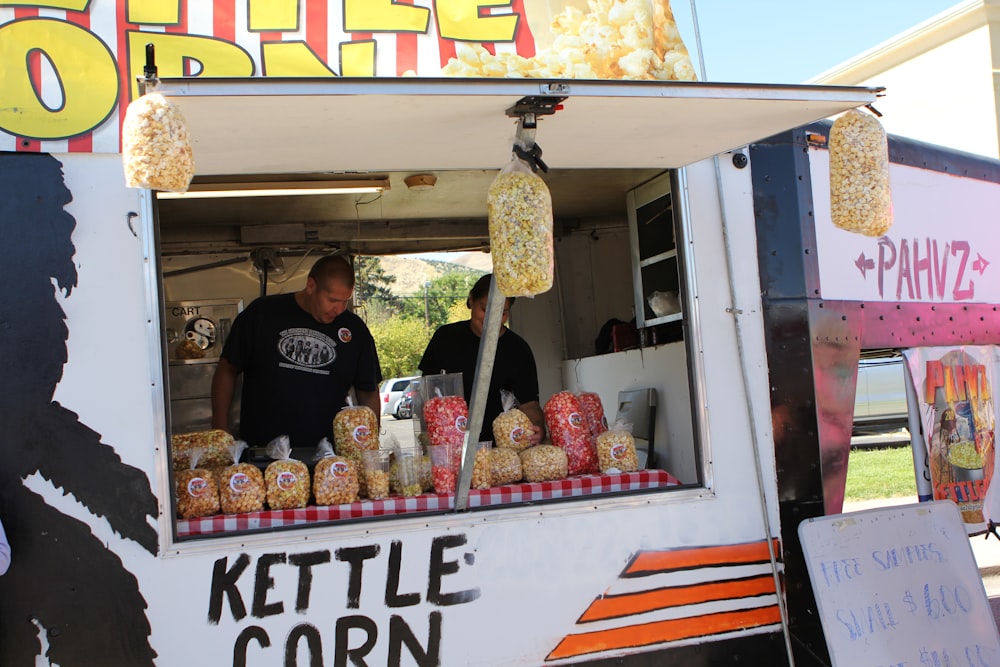 a couple of people standing at a food truck