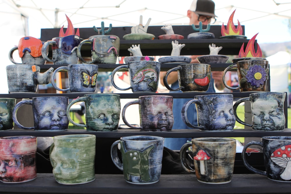 a table topped with lots of different colored coffee mugs