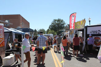 A lively pop-up shop setup with happy customers enjoying food.