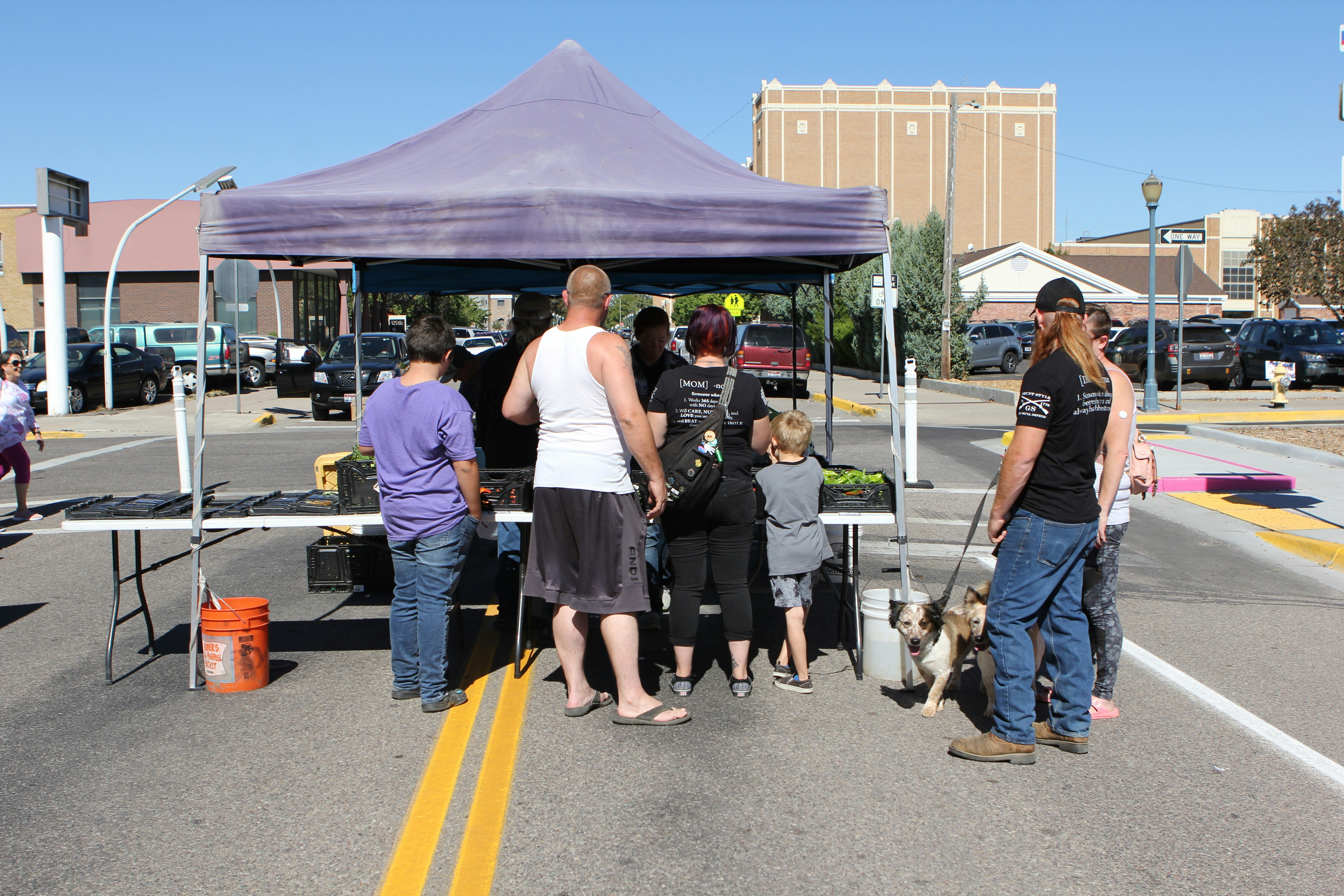 a group of people standing under a purple tent