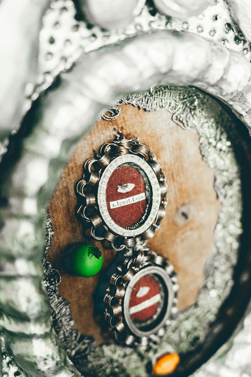 a close up of a metal object with a green ball