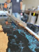 Custom mold being crafted with precision tools on a workbench surrounded by composite materials.
