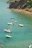 A small group of swimmers enjoying a calm, crystal-clear bay with the cruise ship anchored nearby.