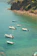 A small group of swimmers enjoying a calm, crystal-clear bay with the cruise ship anchored nearby.