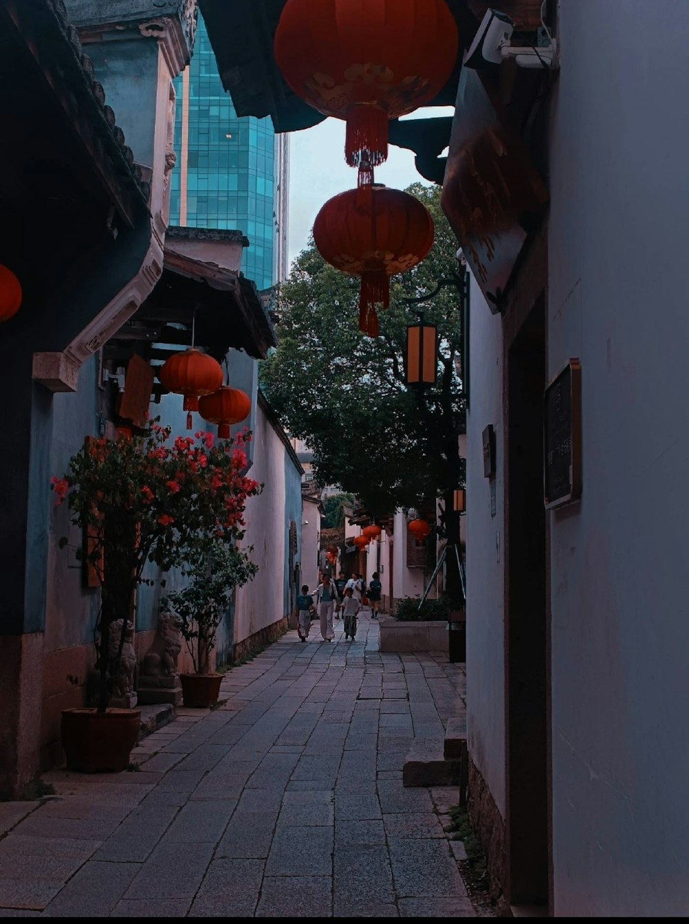 a narrow street with lanterns hanging from the buildings
