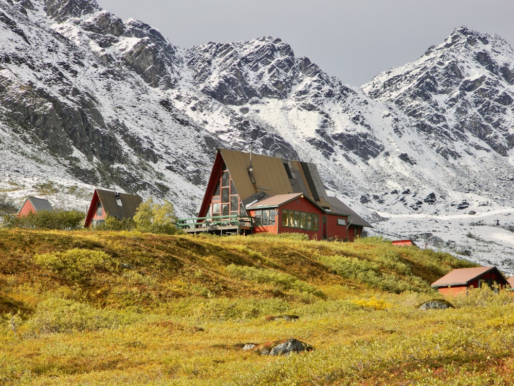 a red house sitting on top of a lush green hillside