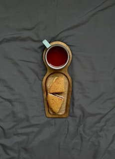 Wooden serving tray with elegant handles holding a cup of tea