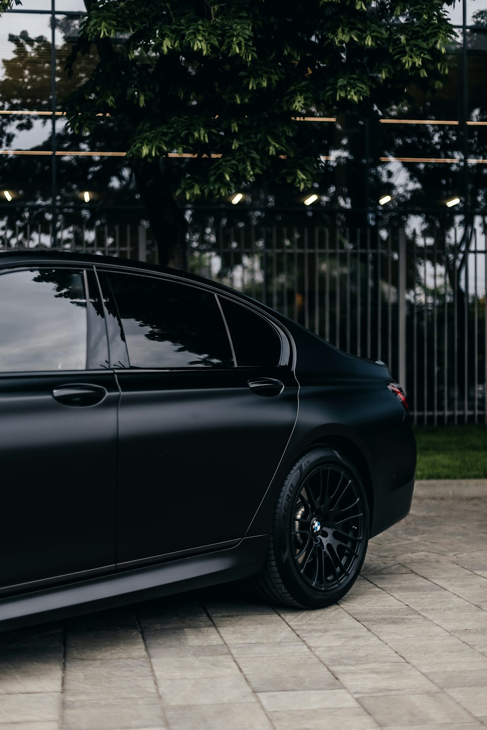 a black car parked in front of a fence