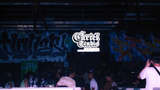 a group of people standing in front of a wall covered in graffiti