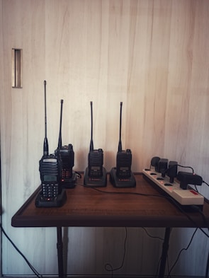 Professional two-way radios lined up on a shelf.