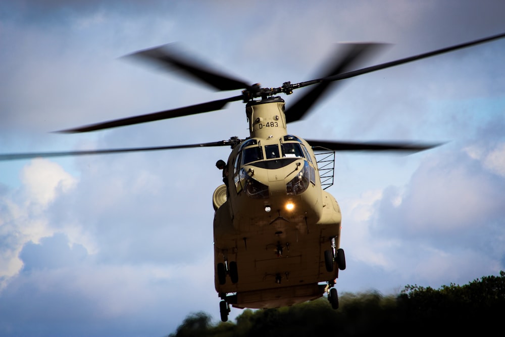 a large helicopter flying through a cloudy blue sky