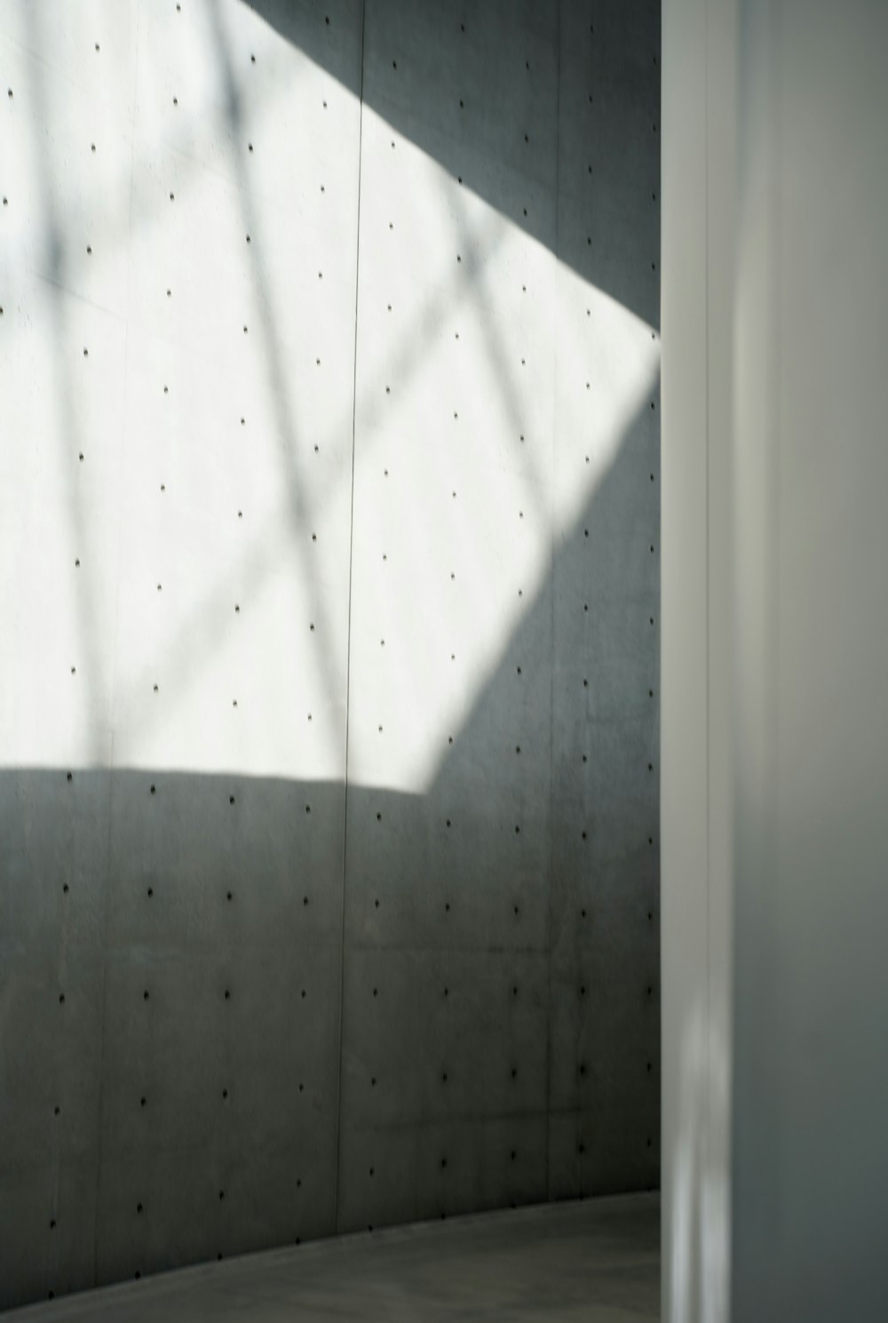 a room with a concrete wall and a window