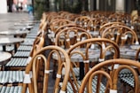 Row of simple chairs outside a small café on a quiet street corner.