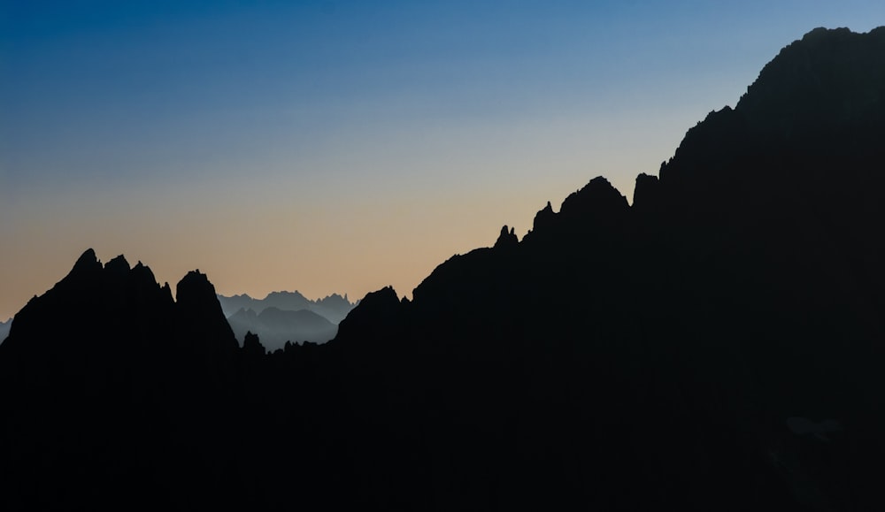 a silhouette of a mountain with a sky in the background