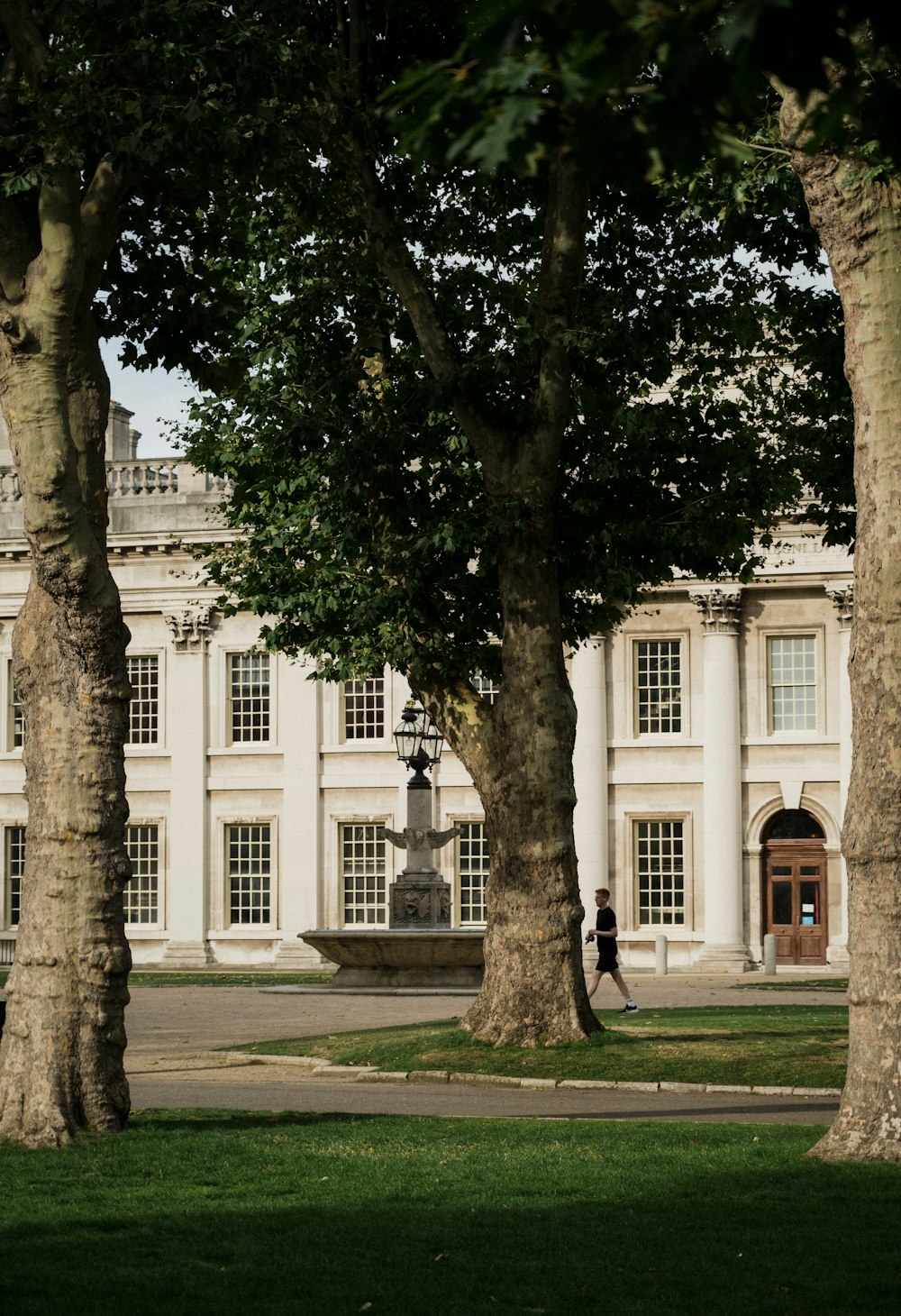 un grande edificio bianco con alberi di fronte ad esso