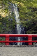 a red bench sitting in front of a waterfall