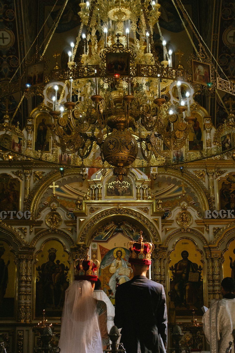 a bride and groom standing in front of a church alter