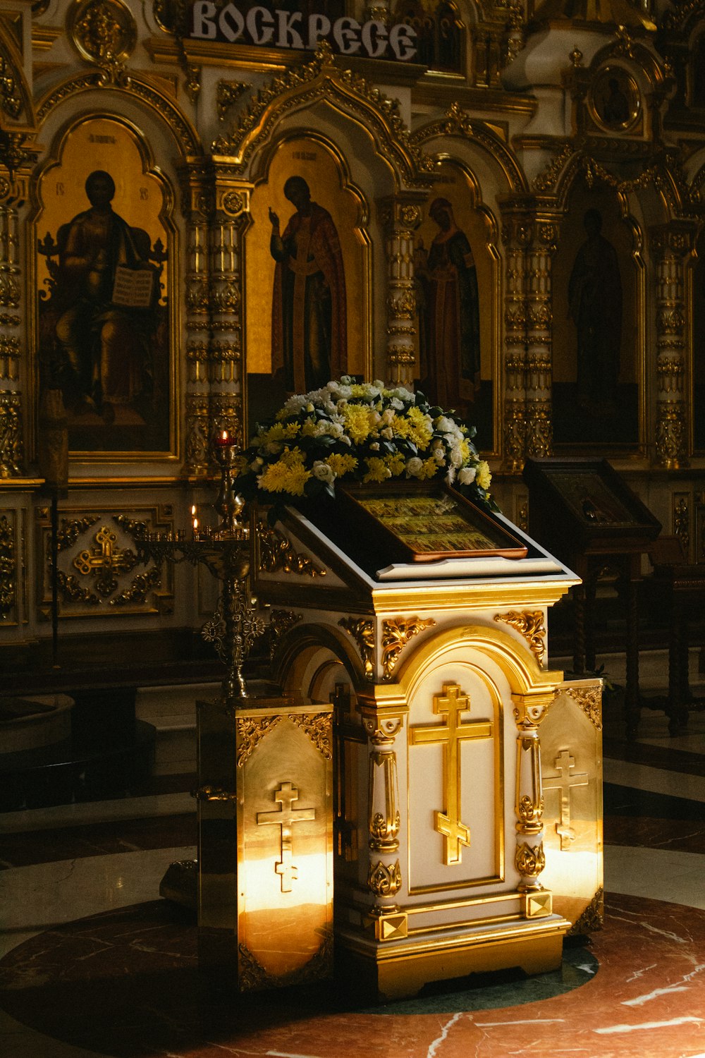 a golden alter with flowers on it in a church