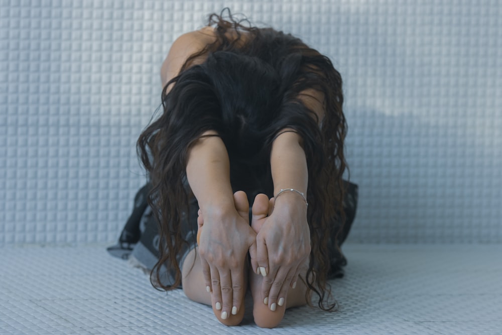 a woman laying on the floor with her hands on her head