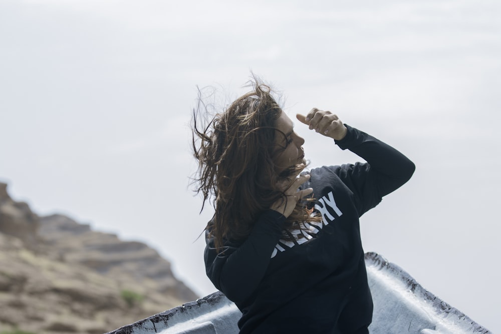 a woman in a black shirt is holding a surfboard