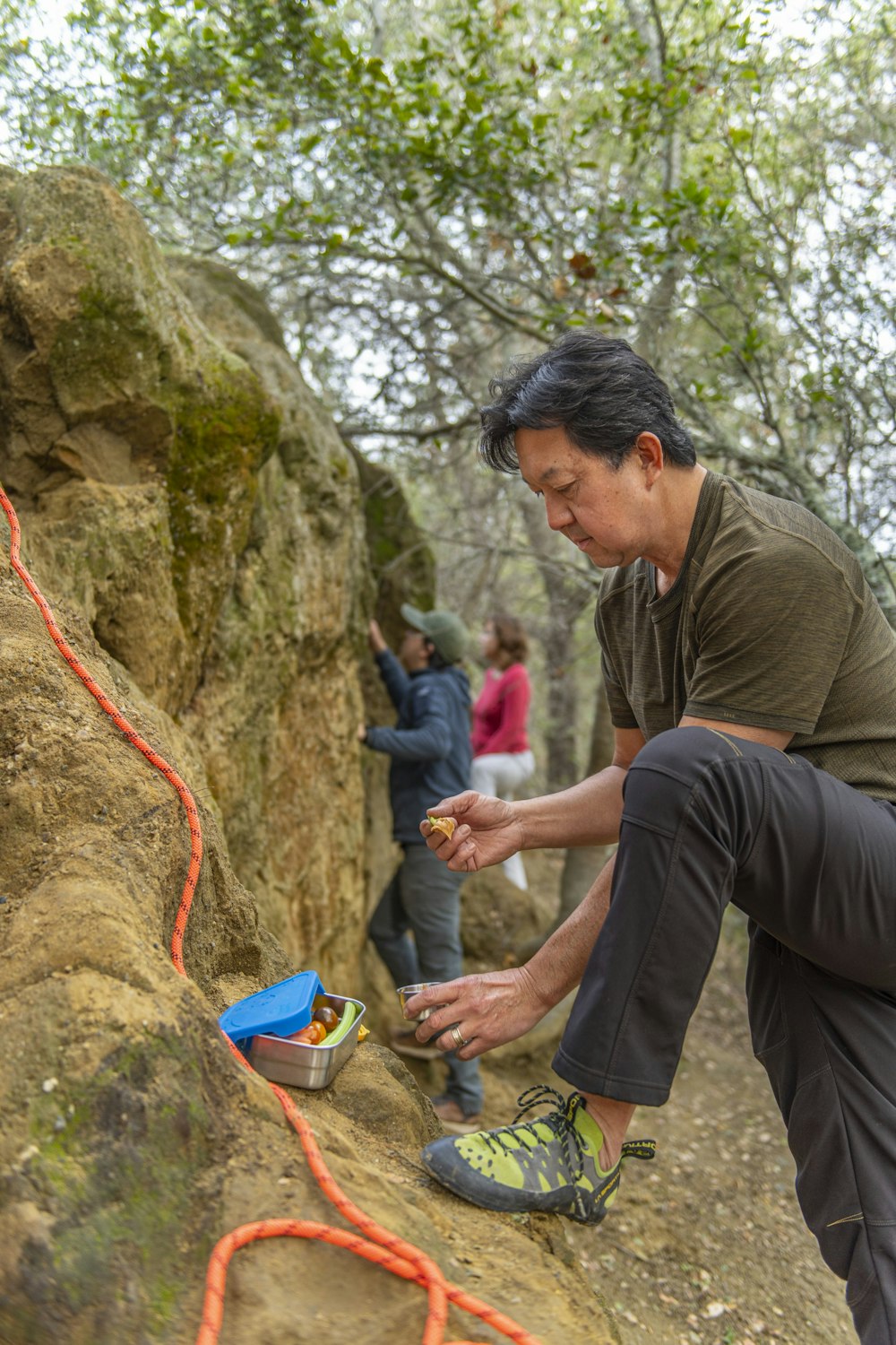 a man is climbing up a rock with a rope