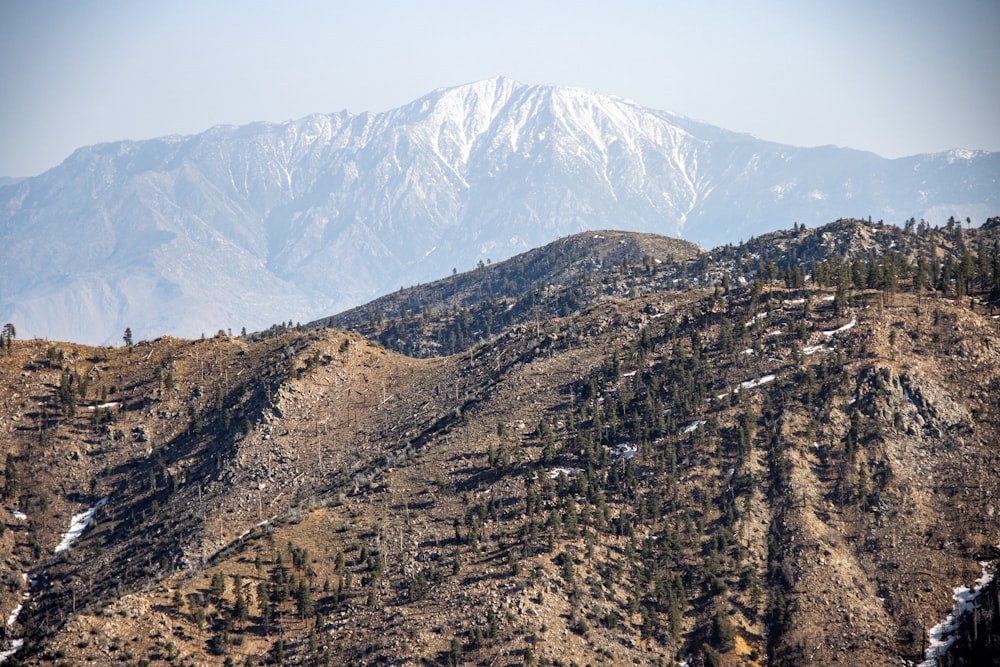 una vista di una catena montuosa con una montagna innevata in lontananza
