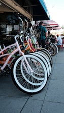 A row of colorful bicycles parked outside a shop, ready for sale.
