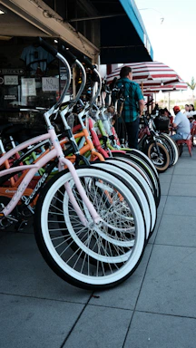A cozy bike shop corner with colorful bicycles lined up and a friendly shopkeeper ready to assist.