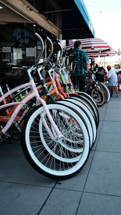 A row of colorful bikes and e-bikes lined up outside the Verdevelo shop near Central Park on a sunny day