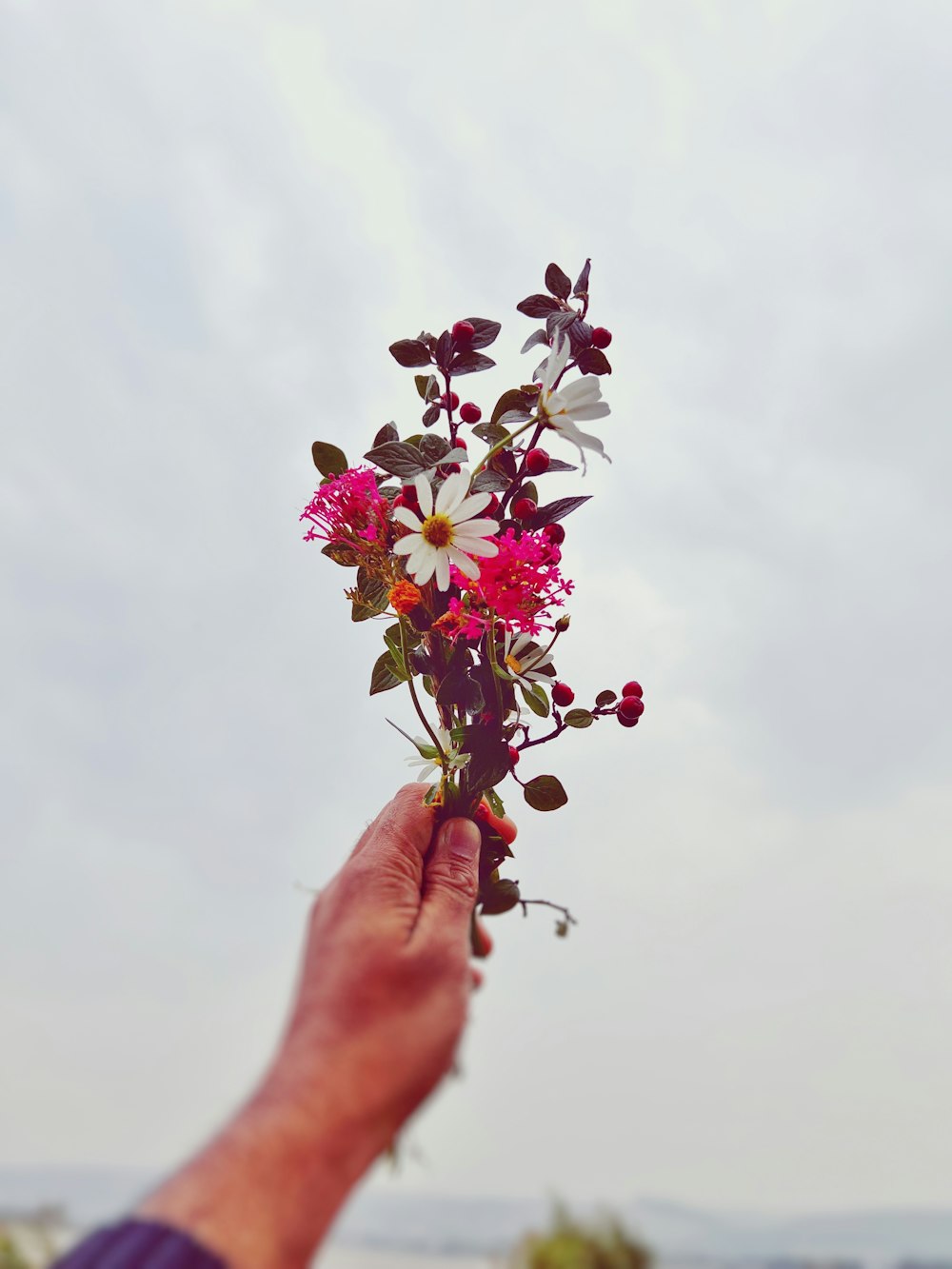 une personne tenant un bouquet de fleurs dans sa main