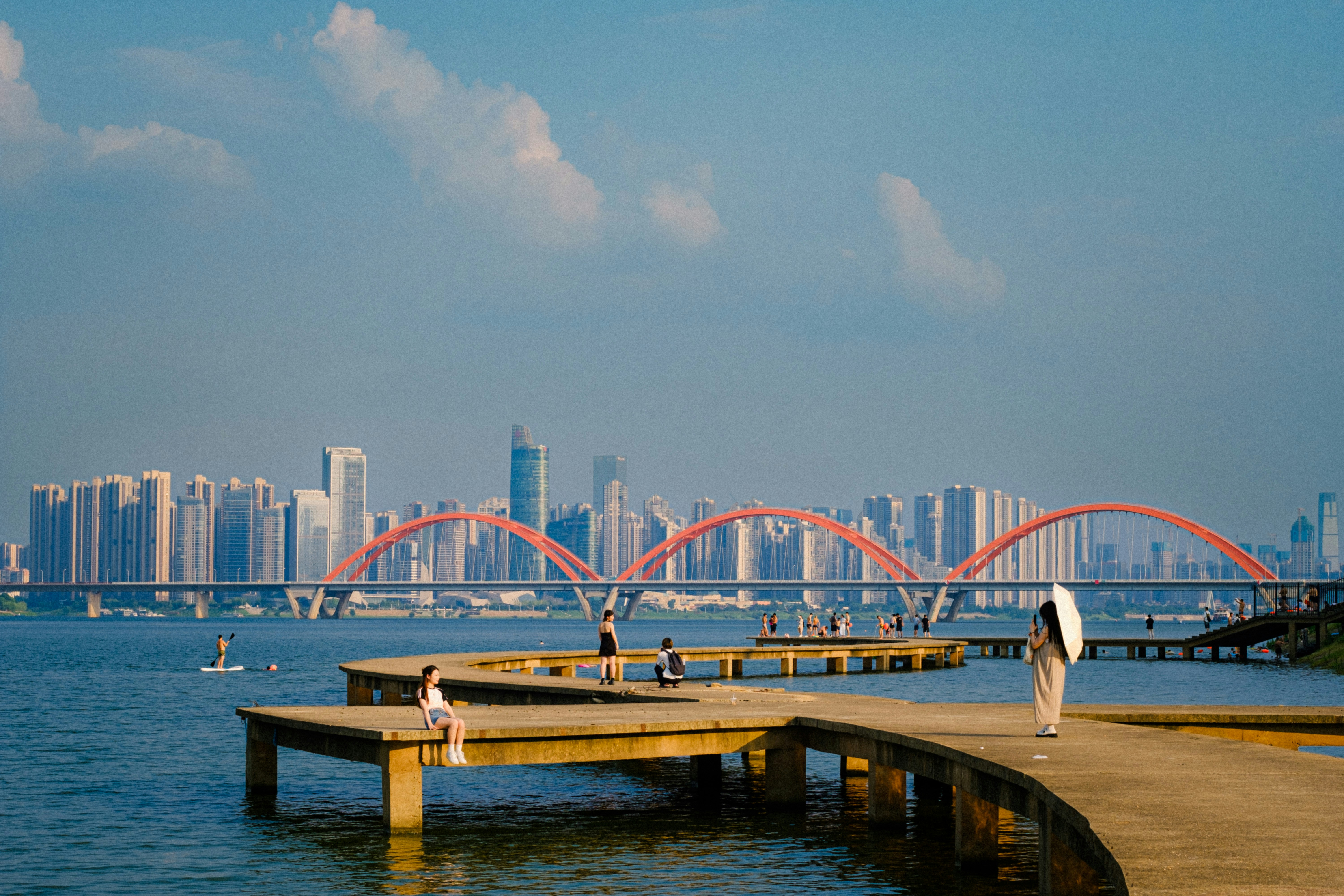 A person walking on a pier near a body of water photo – Free Water ...
