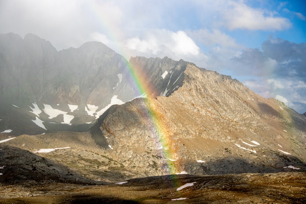 a rainbow in the sky over a mountain range