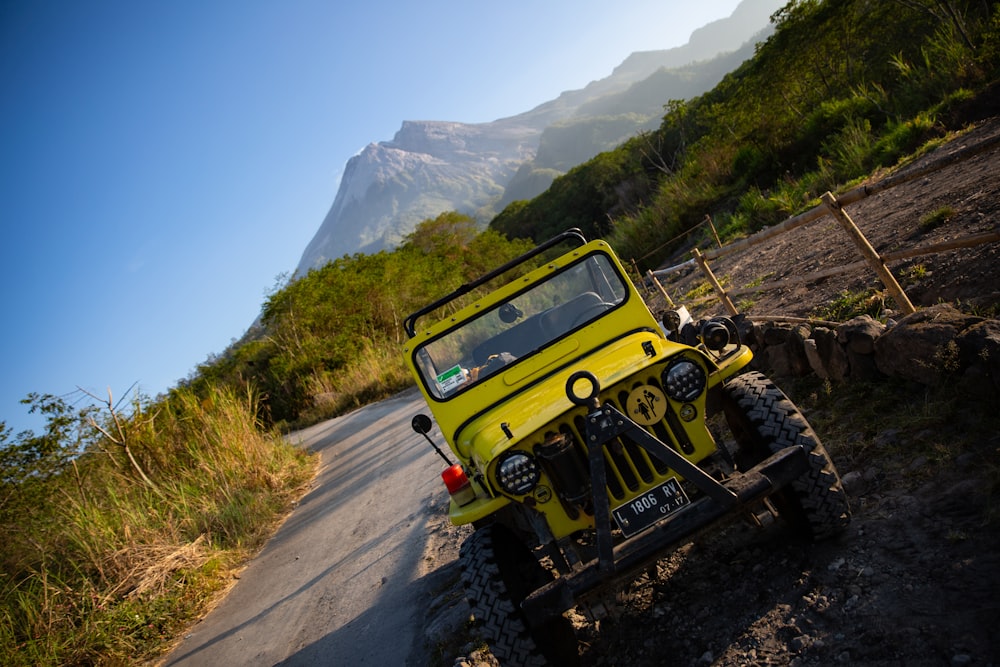 a yellow jeep is parked on the side of the road