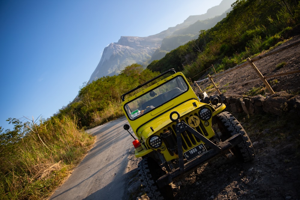 Um jipe amarelo está estacionado na beira da estrada