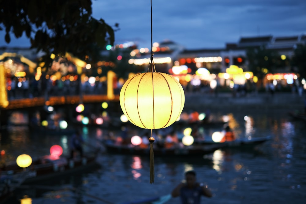 a lantern hanging from a tree over a body of water