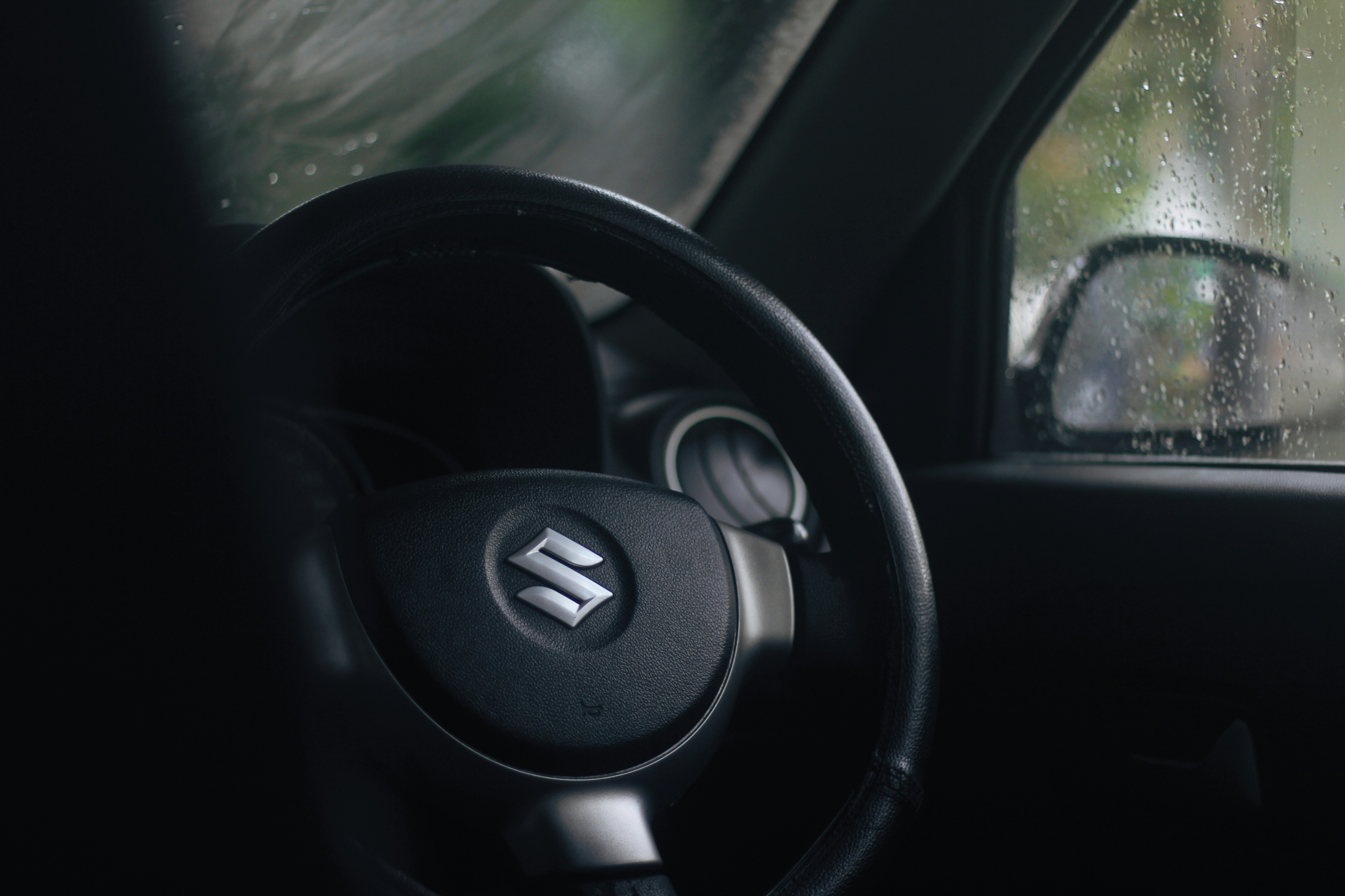 a steering wheel of a car in the rain