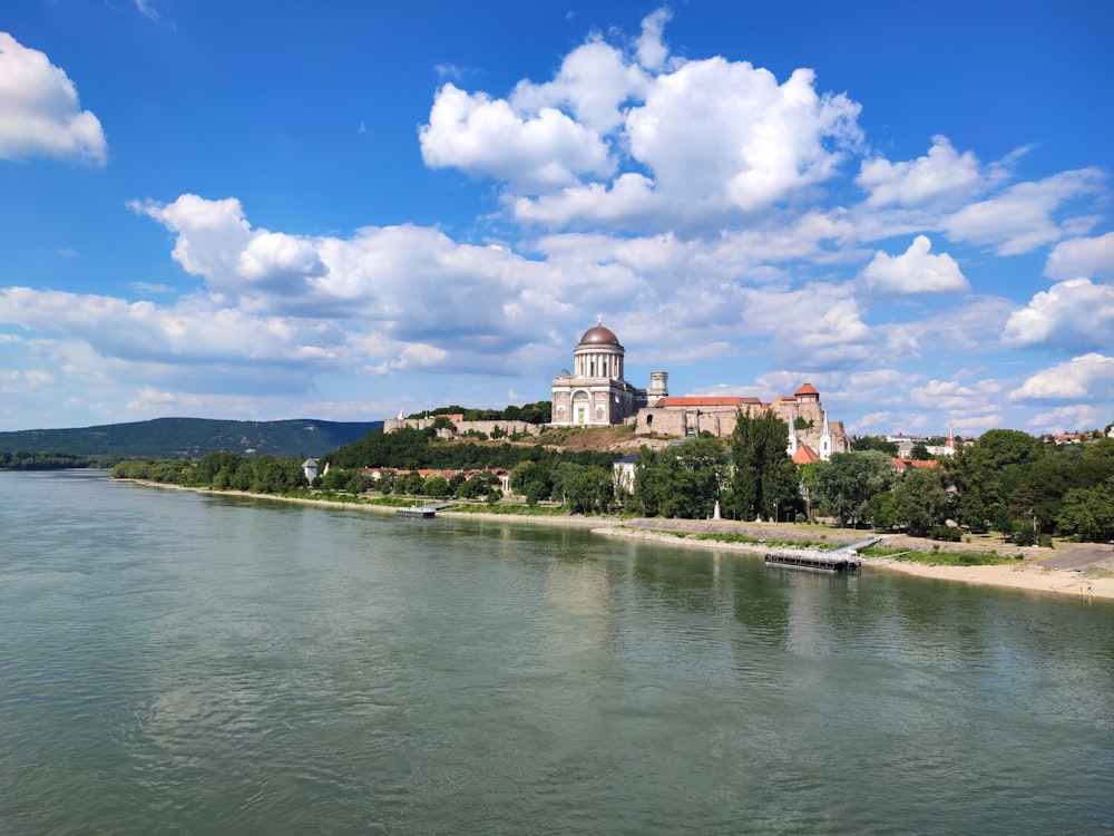 a large building sitting on top of a hill next to a river