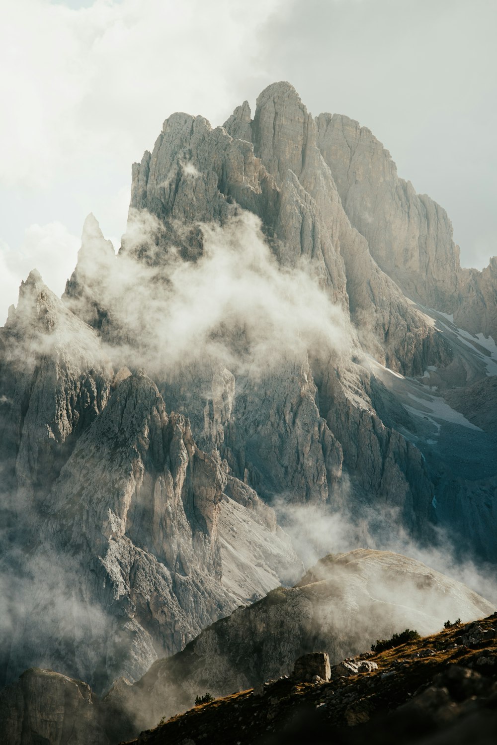 a mountain range covered in fog and clouds