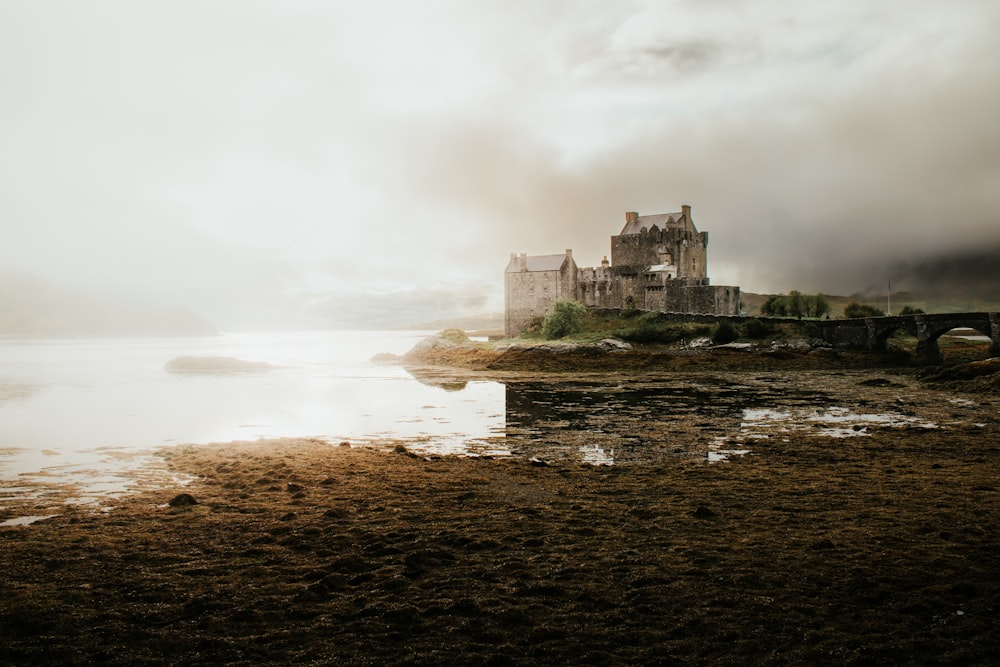 a castle sitting on top of a cliff next to a body of water