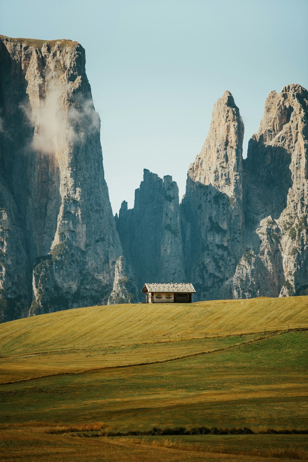 a grassy field with a house in the middle of it