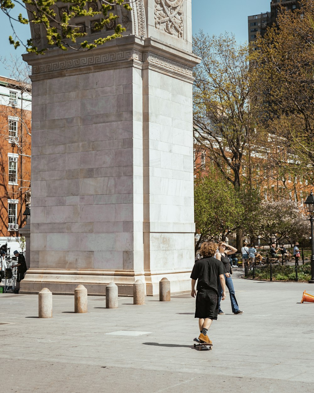 a man riding a skateboard next to a tall clock tower