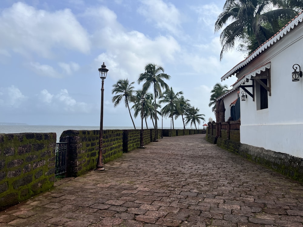 a cobblestone road leading to a white building